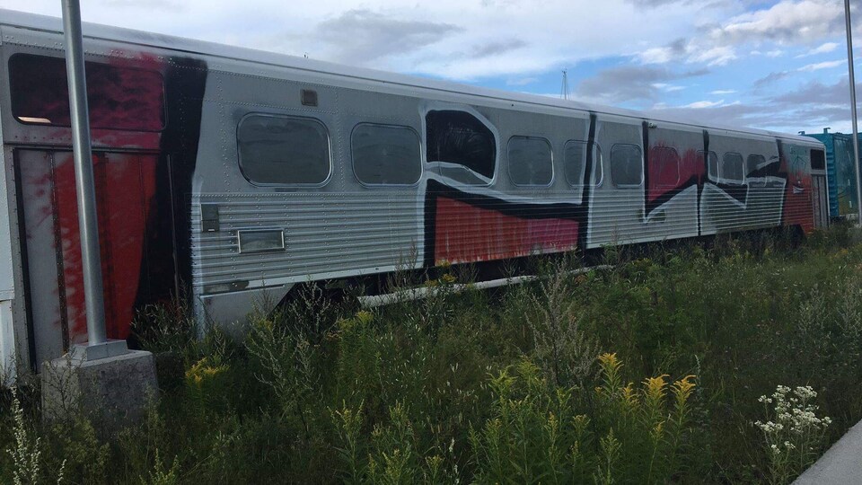 Des lettres ont été peintes en rouge, noir et blanc sur un wagon du train.