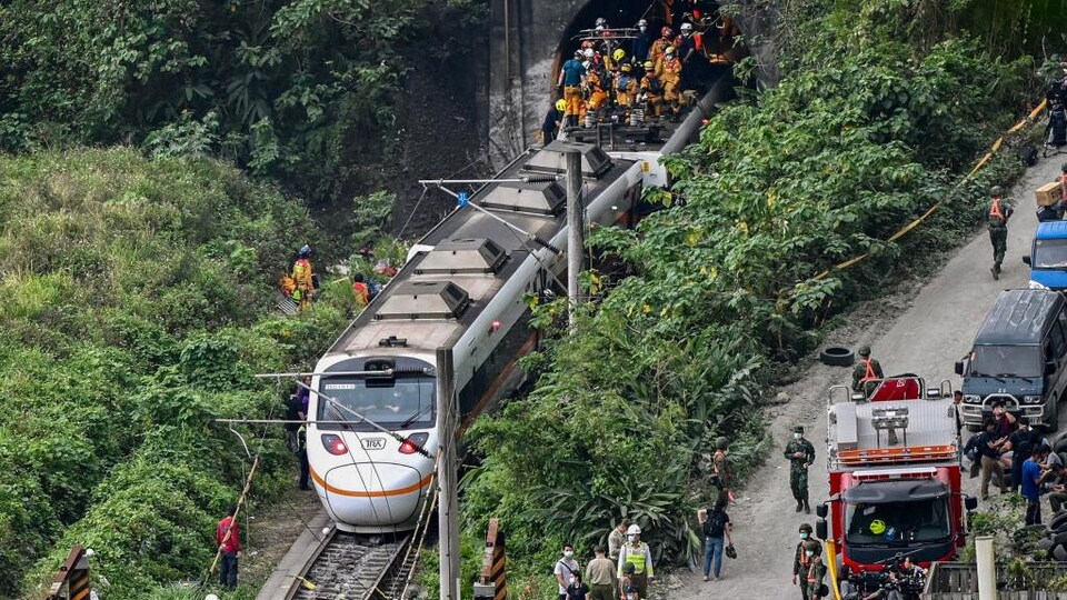 Des équipes de secouristes s'activent autour du site où le train a déraillé, à la sortie d'un tunnel dans les montagnes de Hualien.