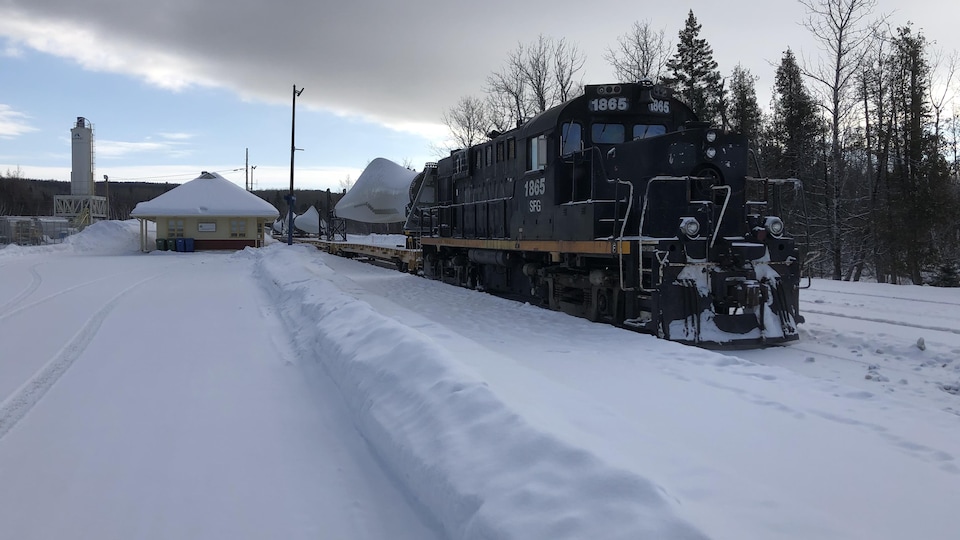Une locomotive sur des rails enneigés.