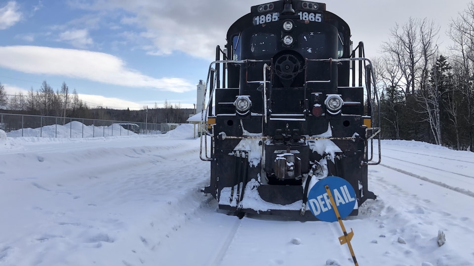 Un train arrêté sur le rail en hiver.