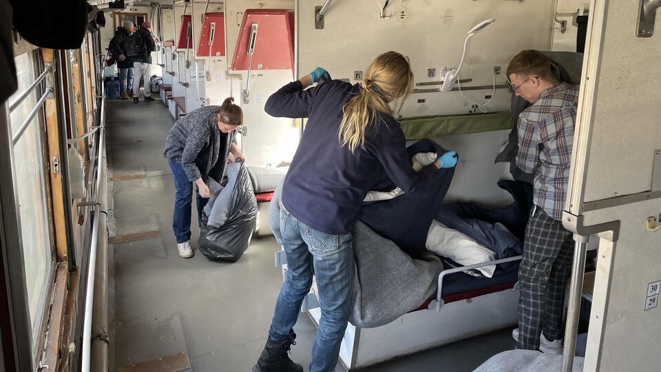 Volunteers prepare beds on a train that has been turned into a hospital.