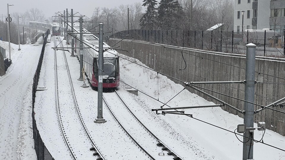 Le train léger d'Ottawa en hiver, sous la neige.