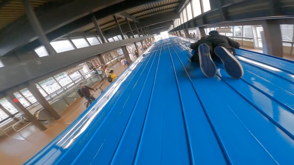 Une personne couchée sur le toit d'une voiture du métro de Toronto, en juillet 2022.