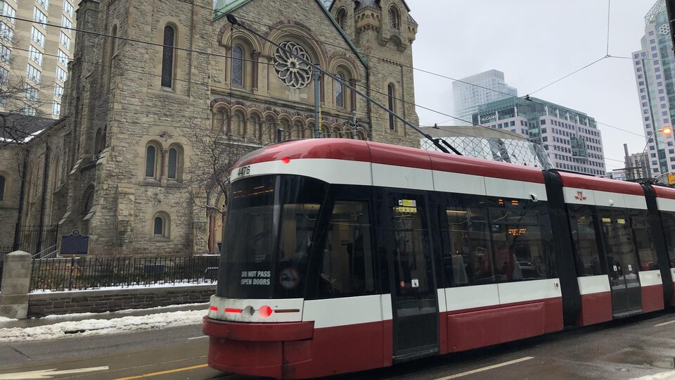 Un tramway passe devant une église.