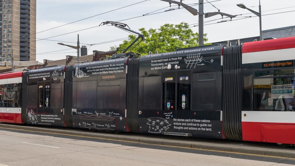 Des dessins illustrant des symboles autochtones sont peints sur un tramway.
