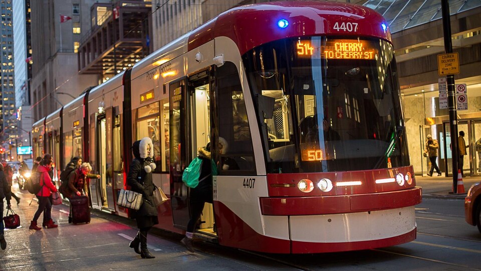 Photo de passagers qui montent à bord d'un tramway.