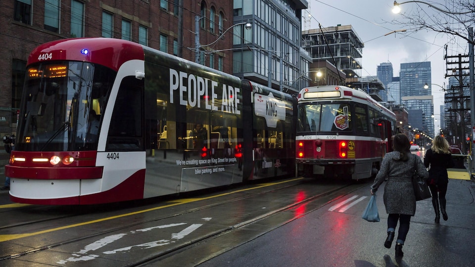 Des femmes courent pour ne pas manquer leur tramway.