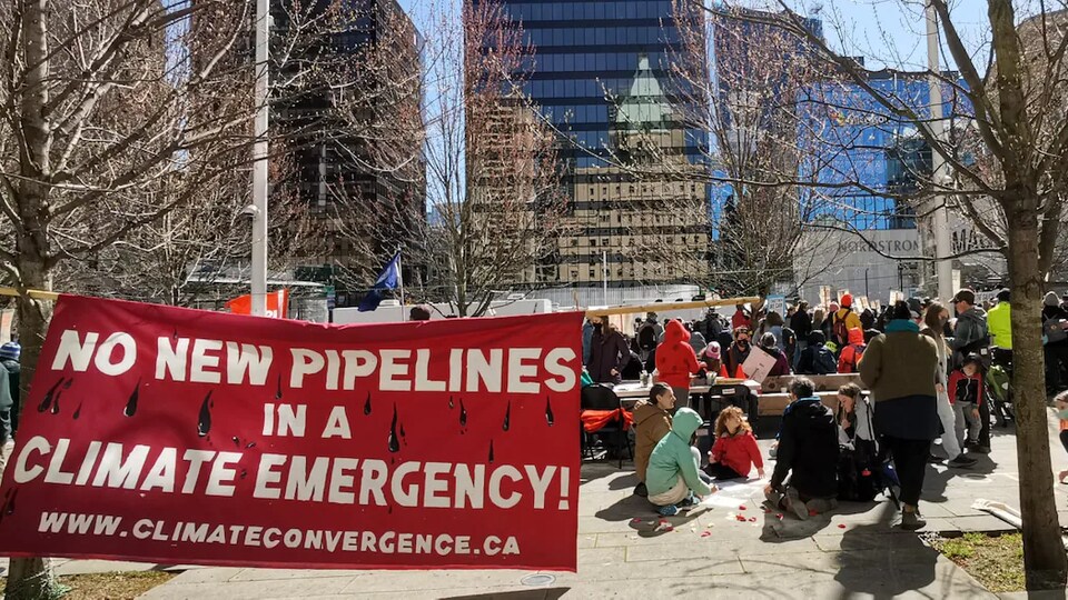 Des manifestants qui dénoncent le pipeline Trans Mountain sont rassemblés devant le Musée des beaux-arts de Vancouver.