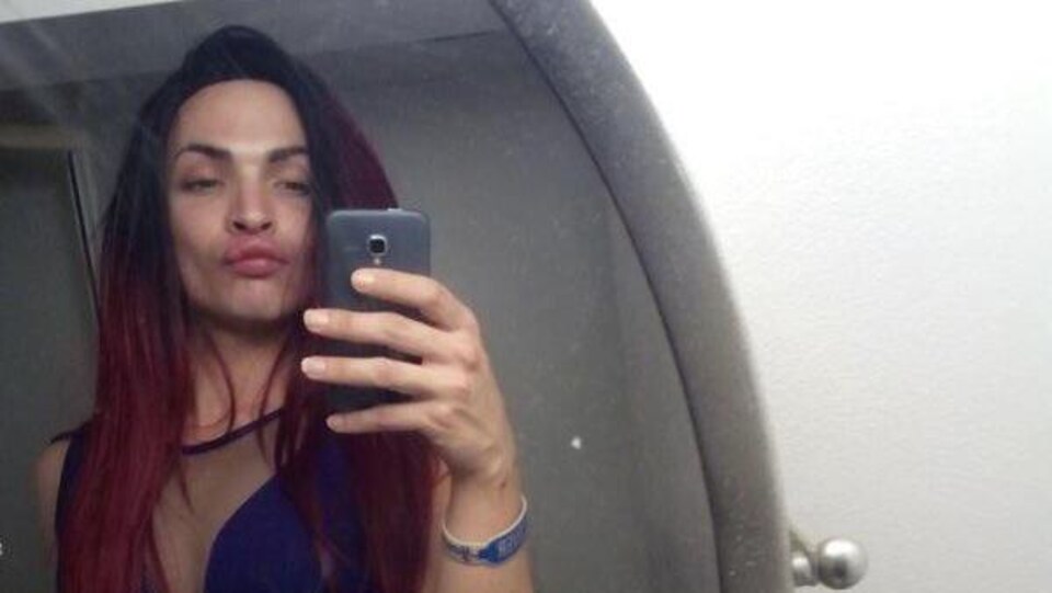 Alloura Wells se prend en photo avec son téléphone devant un miroir.