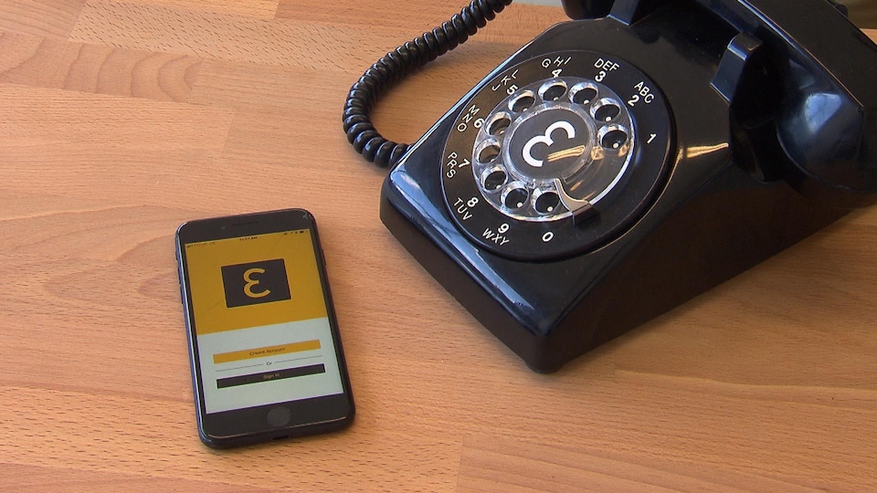 Un téléphone intelligent affichant le logo d'Eva aux côtés d'un téléphone à cadran.