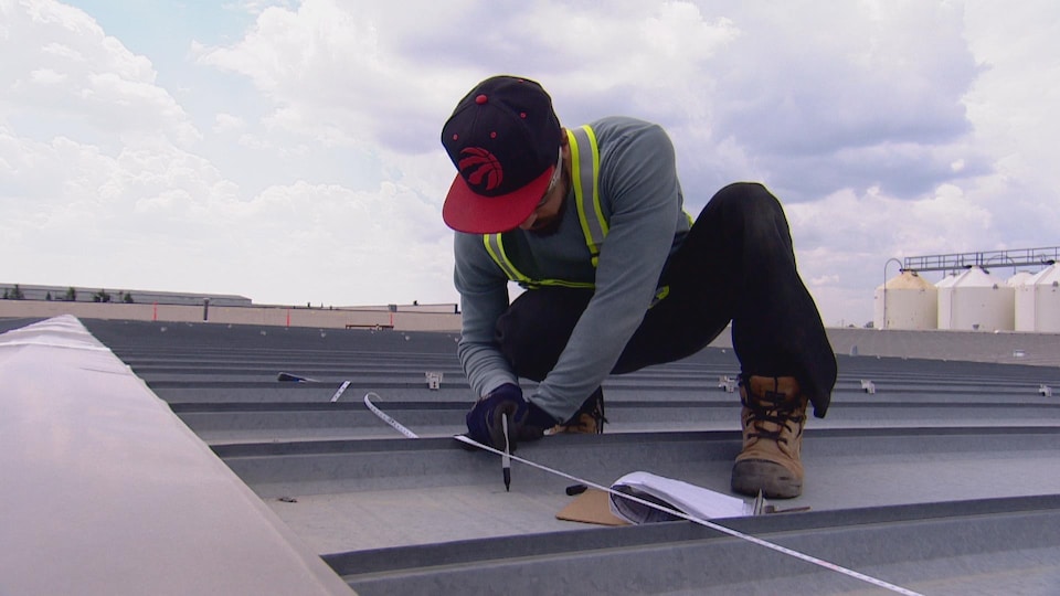 Un travailleur de l'énergie solaire sur un toit. 