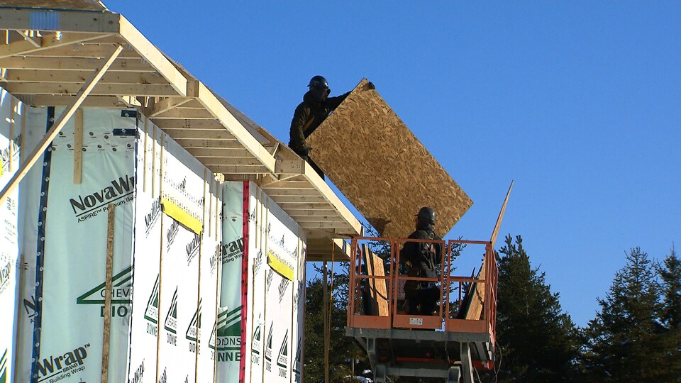 Des travailleurs de la construction s'affairent à construire un duplex. 