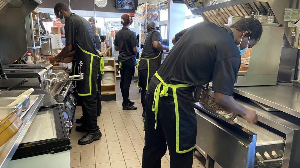 Des travailleurs étrangers camerounais dans une cuisine de restaurant.