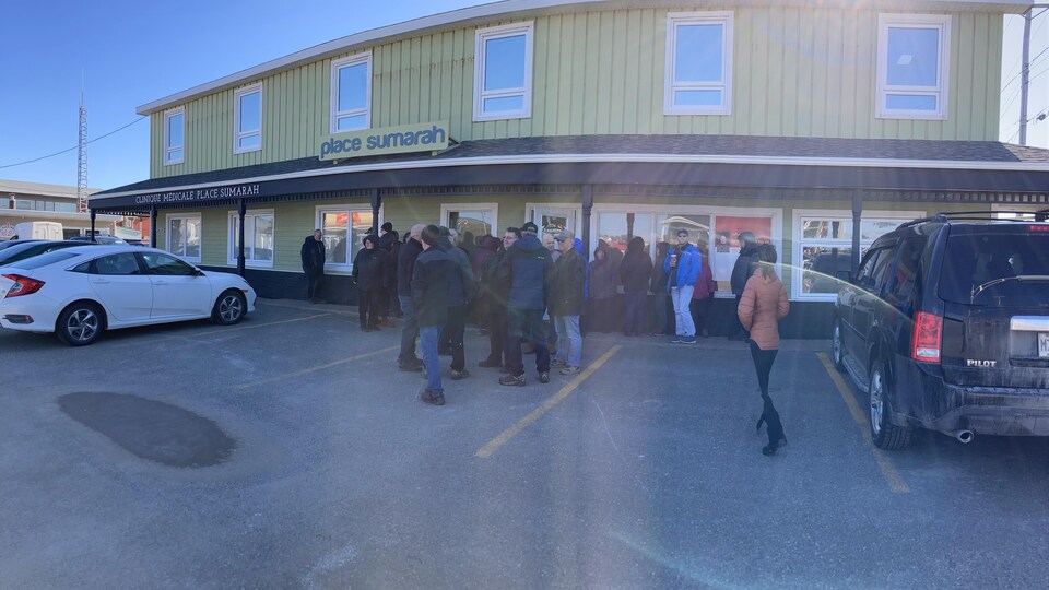 Des gens massés dehors devant l'immeuble où est situé le bureau de circonscription de Diane Lebouthillier.