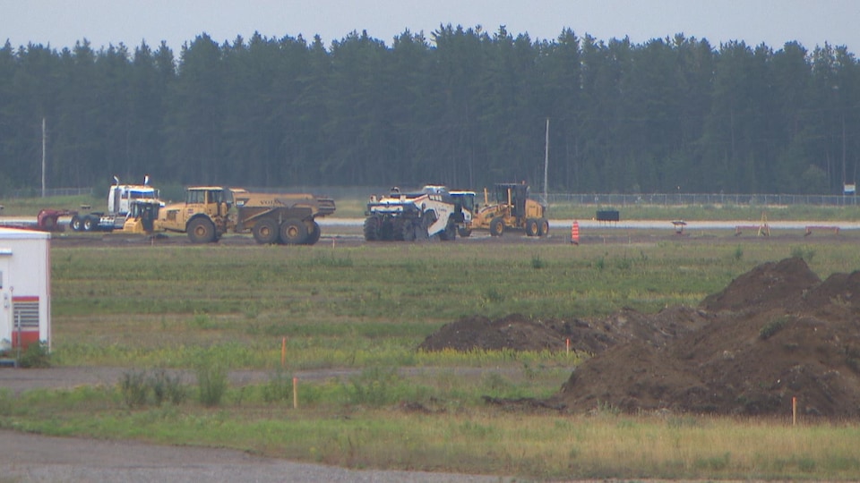 Des machines travaillent sur la piste de l'aéroport.