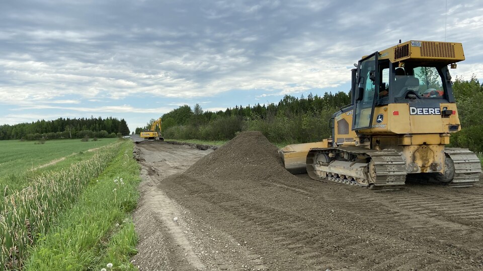 Des véhicules lourds sur une route en gravier.