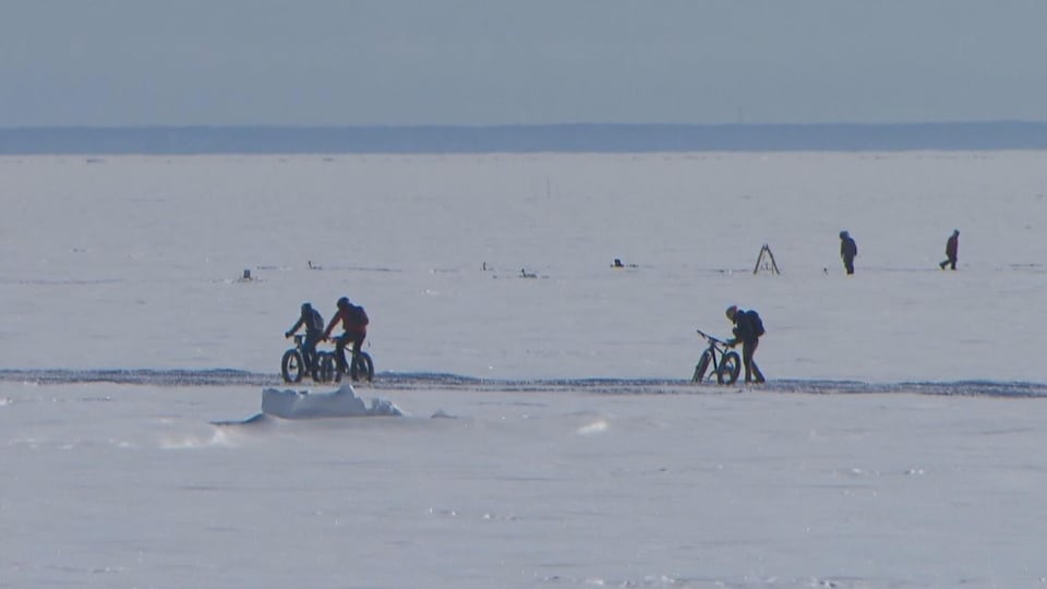 Le lac Saint-Jean gelé et quelques cyclistes en action
