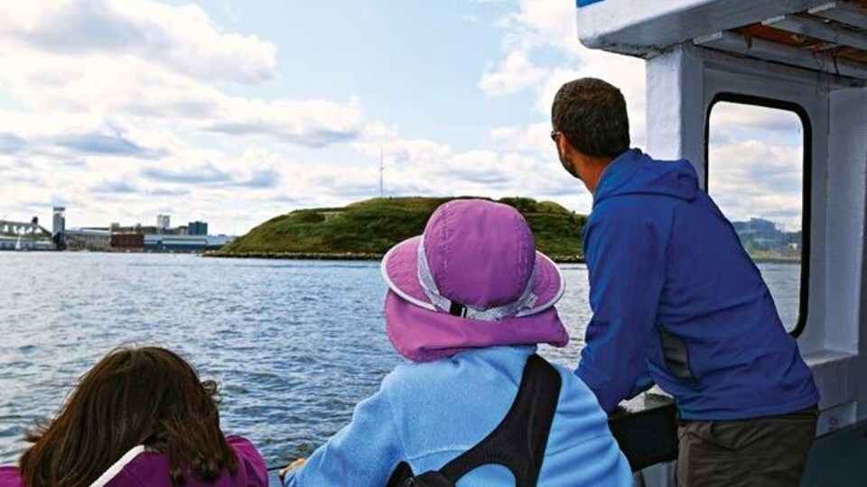 Un homme, une femme et une fille sont sur un bateau au large de l'île Georges.