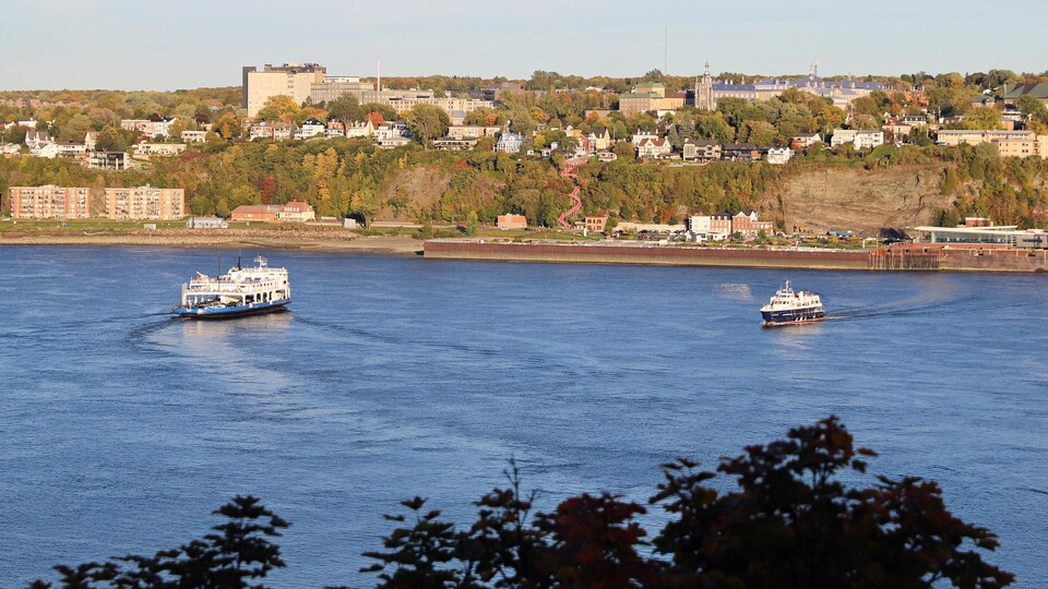 Le fleuve Saint-Laurent sur lequel naviguent deux traversiers. En arrière-plan, la côte de Lévis 