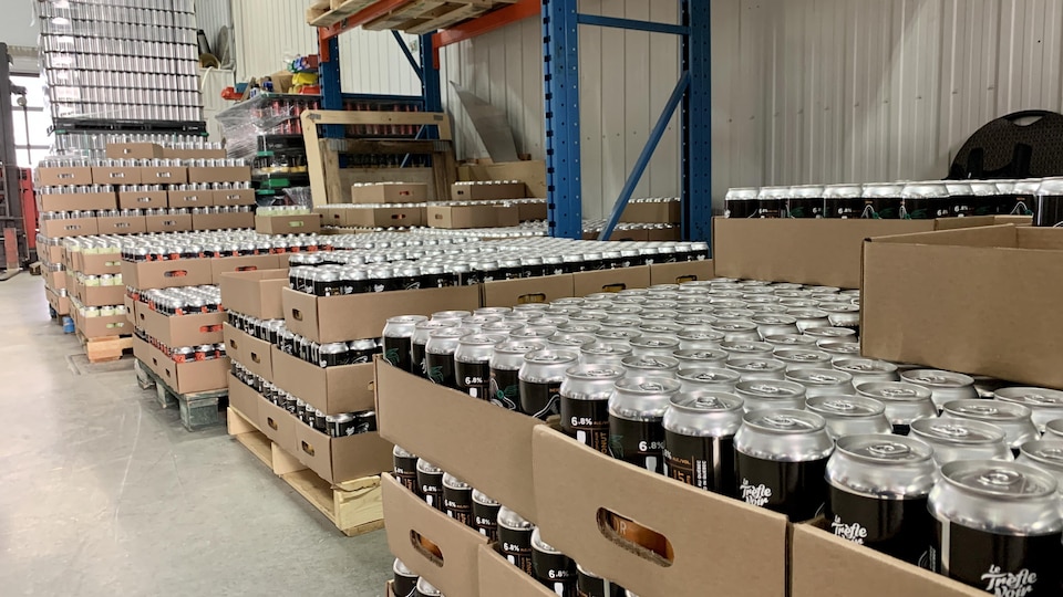 Des dizaines de canettes de bière du Trèfle Noir dans un entrepôt.