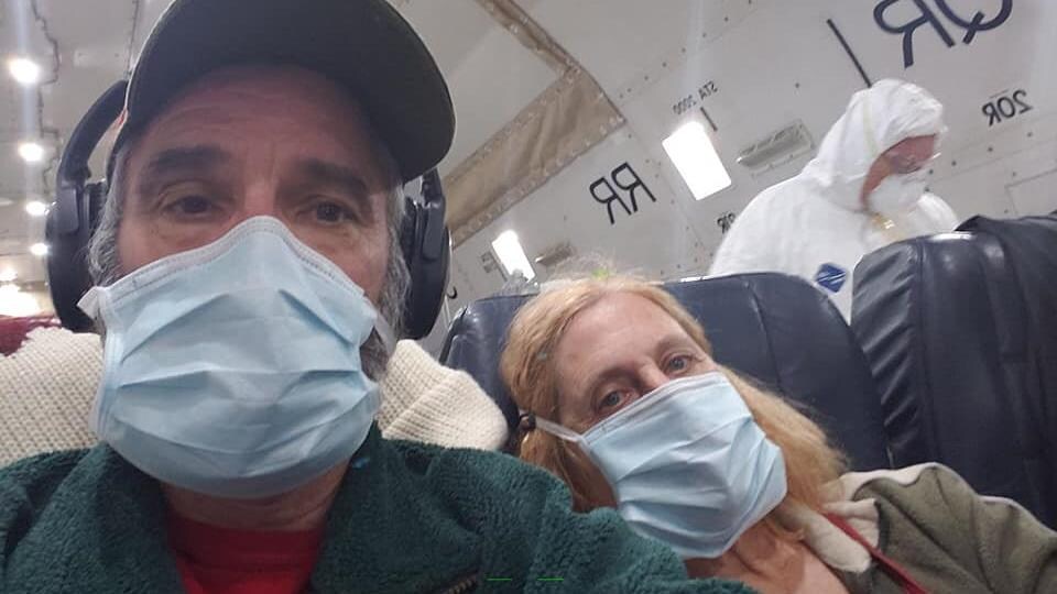 Mike Zrobin portant un masque assis dans l'avion.