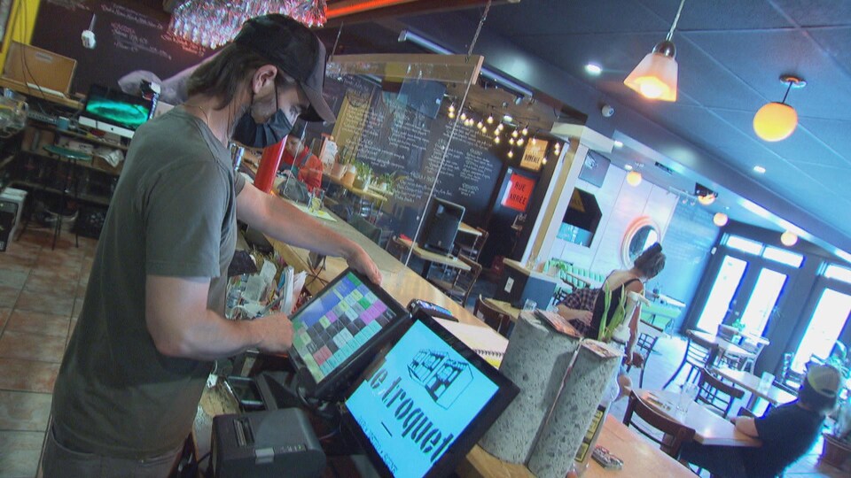 Un serveur prend la commande d'un client dans un bar.