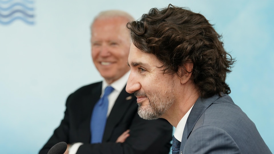 Justin Trudeau avec Joe Biden en arrière-plan.