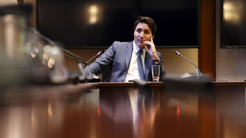 Le premier ministre Trudeau en entrevue devant une table de conférence.