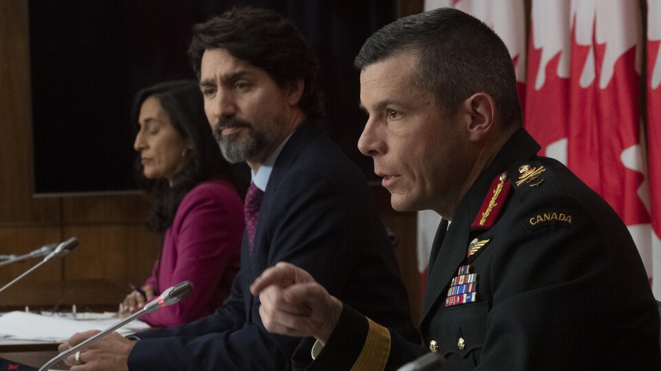 Anita Anand, Justin Trudeau et Dany Fortin assis derrière des micros pour une conférence de presse.