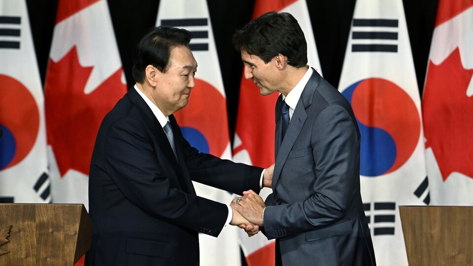 Le président de la Corée du Sud Yoon Suk-yeol et le premier ministre du Canada Justin Trudeau se serrent la main.