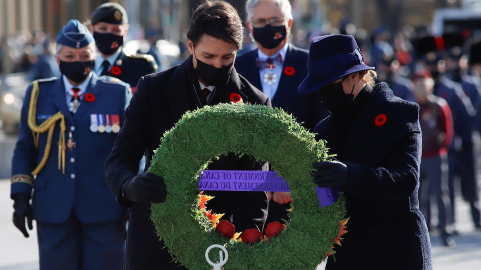 Justin Trudeau et Sophie Grégoire tiennent une couronne de fleurs,