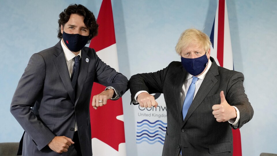 Justin Trudeau et Boris Johnson se donnent le coude lors d'une séance de photo.