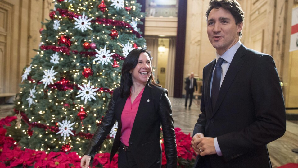 Valérie Plante et Justin Trudeau devant un sapin de Noël dans le hall de l'hôtel de ville de Montréal.