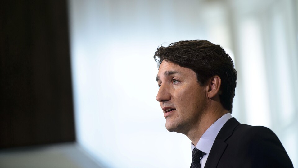 Justin Trudeau en costume en train de parler.