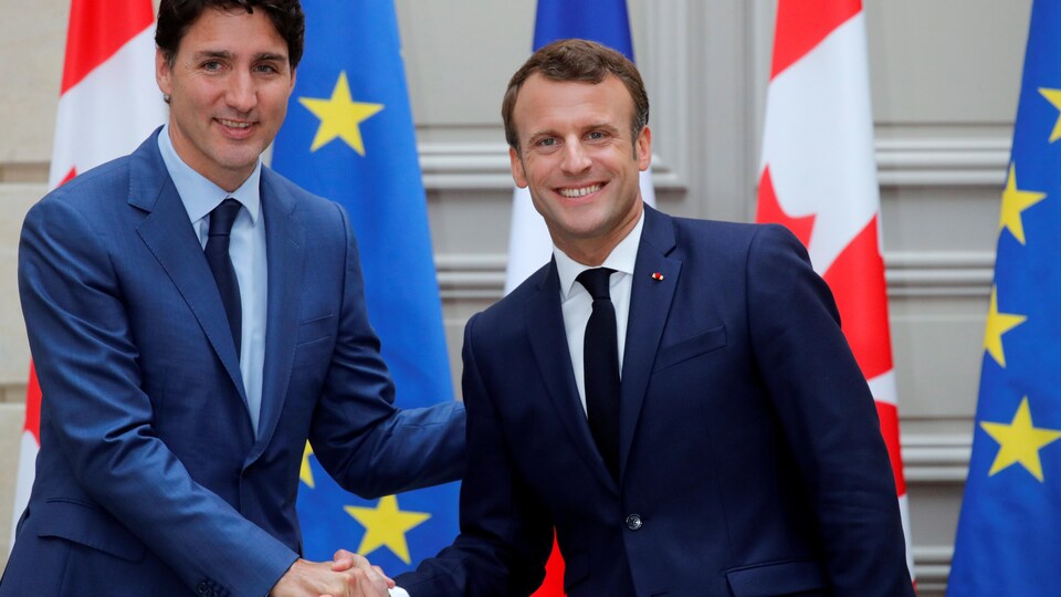 Justin Trudeau serre la main d'Emmanuel Macron.