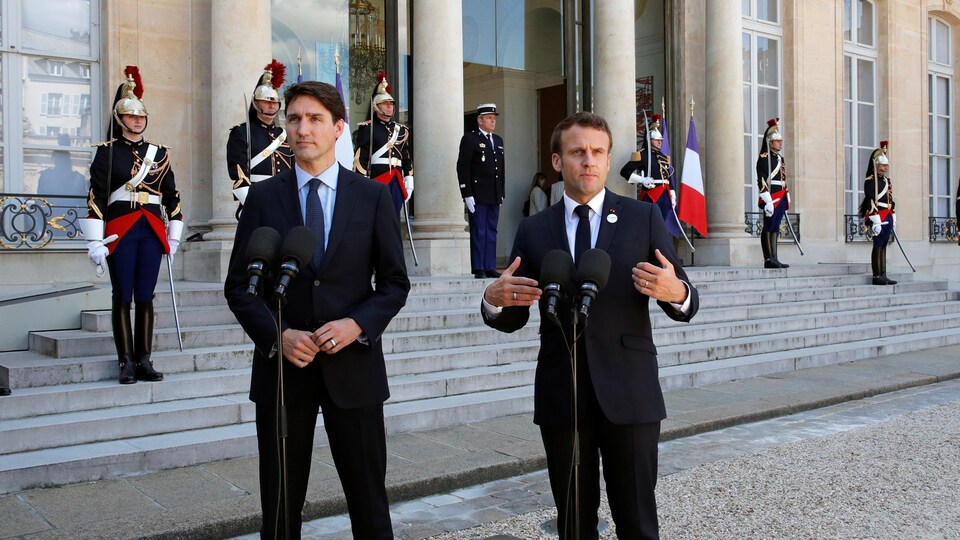 Justin Trudeau et Emmanuel Macron parlent au micro.