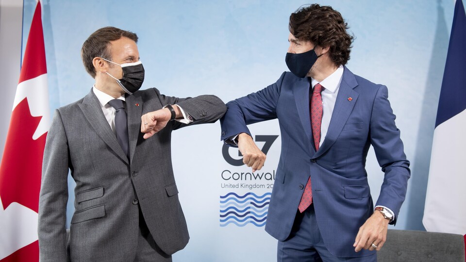 Les deux hommes se donnent l'accolade avec le coude.