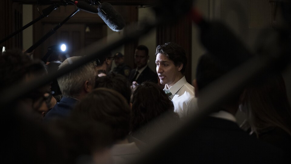 Monsieur Trudeau entouré de journalistes et de micros.