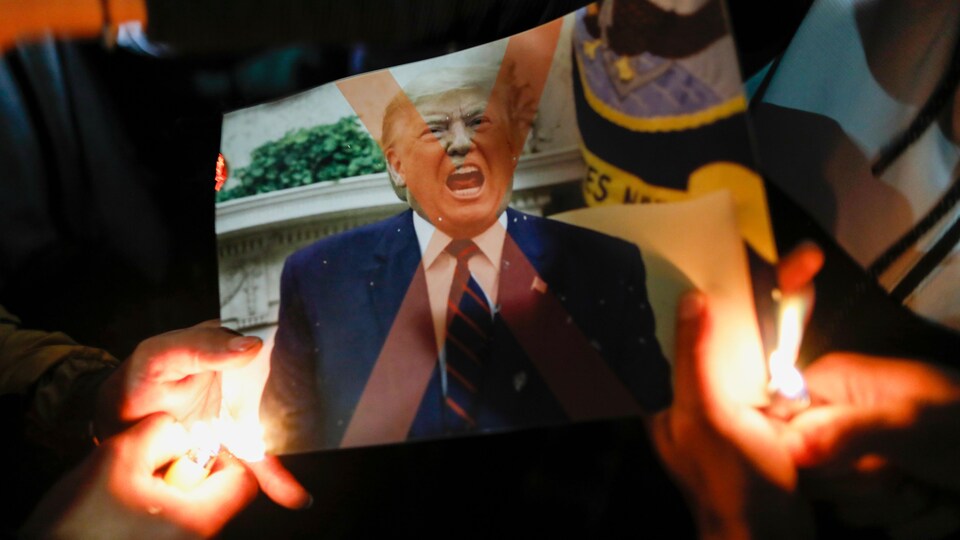 Une photo de Trump en train de crier brûlée par des manifestants avec des briquets.