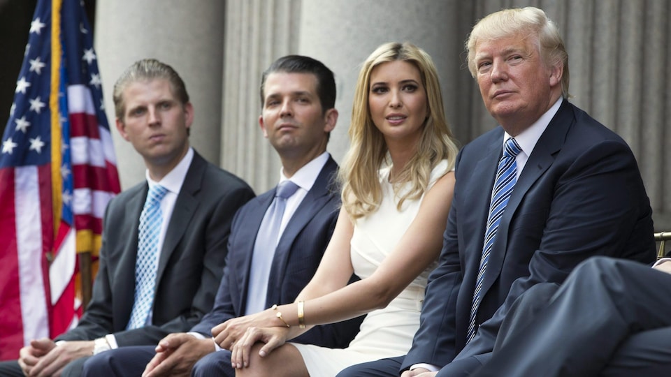 De gauche à droite, Eric Trump, Donald Trump fils, Ivanka Trump et leur père, Donald Trump, sont assis lors d'une cérémonie.