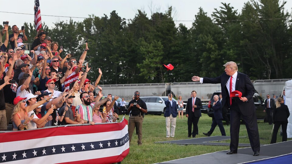 Donald Trump lançant des casquettes à des spectateurs.