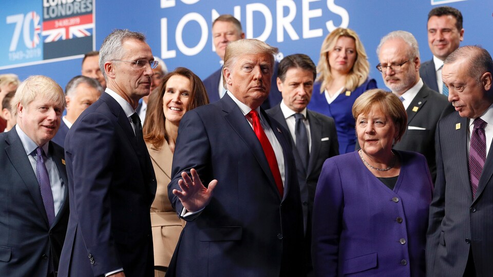 Donald Trump fait un signe de la main en quittant une scène qu'il partageait avec d'autres dirigeants.