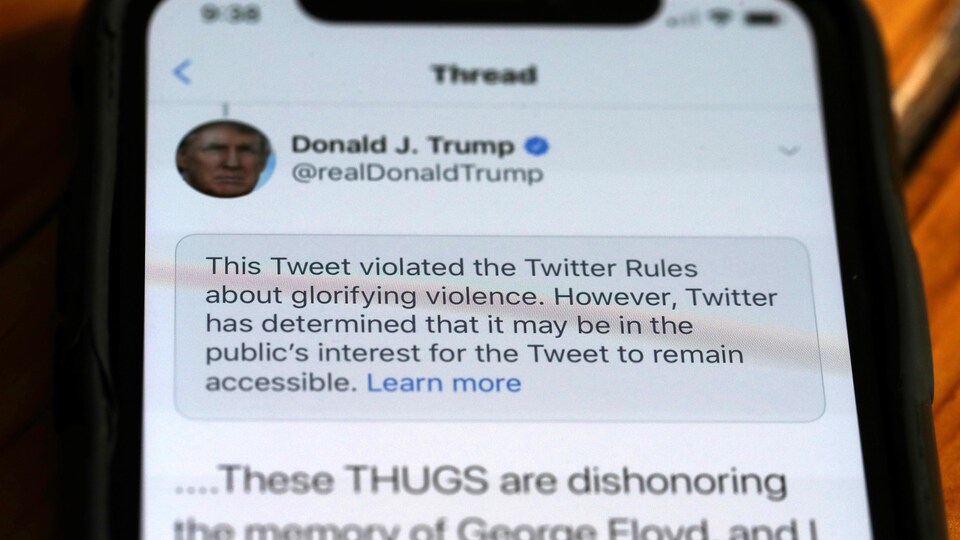 Une écran de téléphone intelligent montre un message de Twitter expliquant la suppression d'un gazouillis de Donald Trump.  