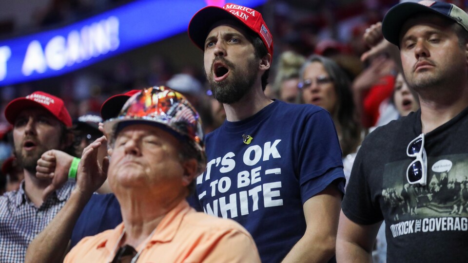 Un partisan de Donald Trump qui porte un tee-shirt sur lequel est écrit « C'est OK d'être blanc ».