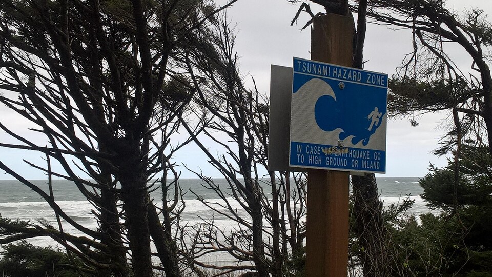 En cas de tsunami, un panneau le long d'une plage en Oregon conseille aux promeneurs de se réfugier sur les hauteurs.

