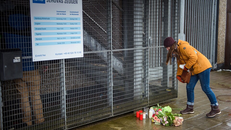 Une femme dépose des fleurs devant le centre de Témoins de Jéhovah où a eu lieu la tuerie.
