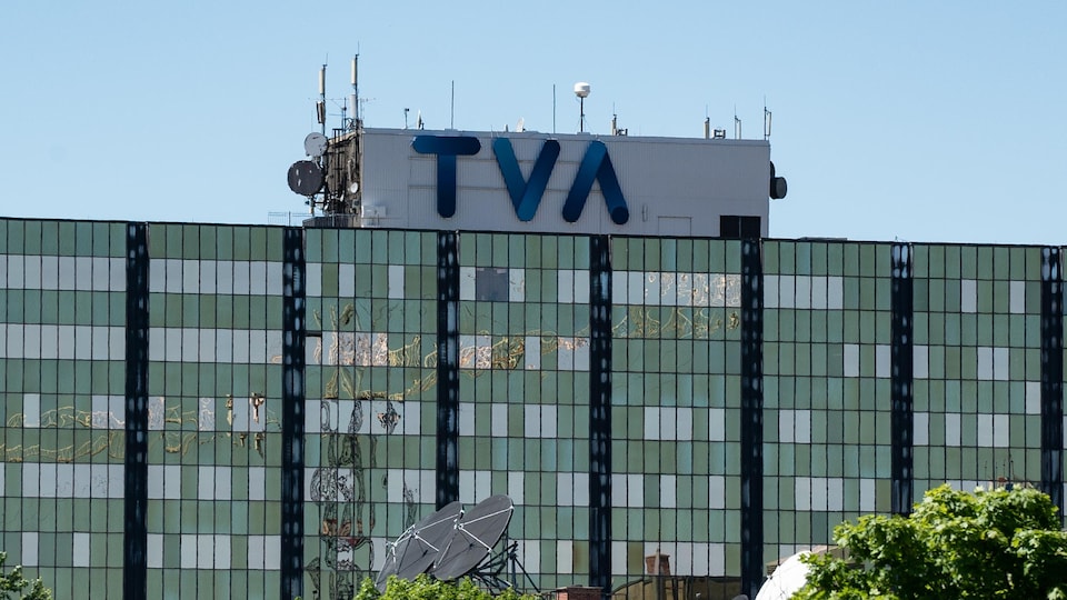 Immeuble avec le logo bleu de TVA sur le toit.