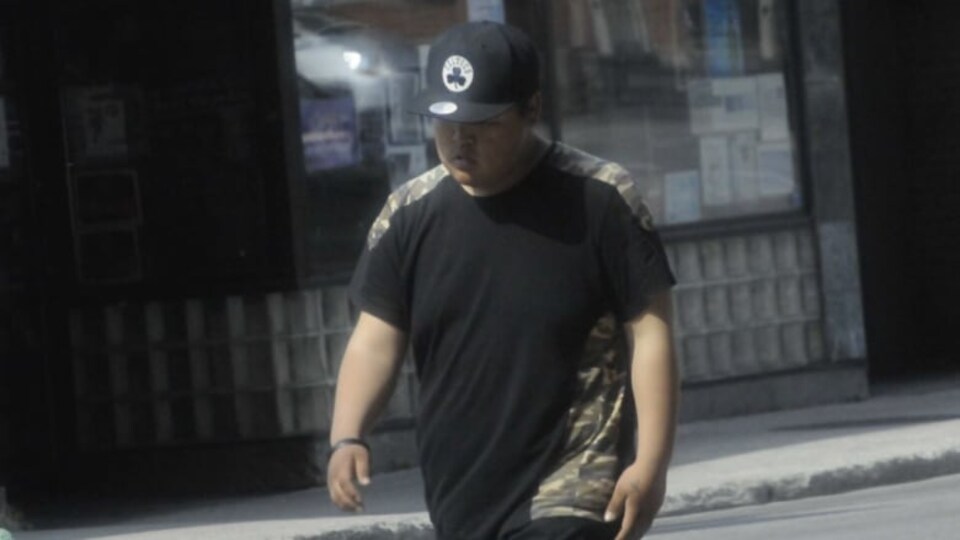 Tyler Hikoalok marche dans la rue.