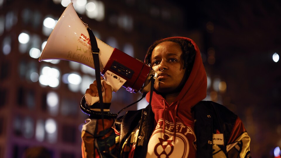 Une manifestante brandit un porte-voix.