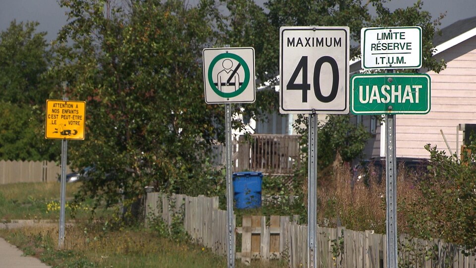 Des panneaux routiers sur une rue de Uashat.